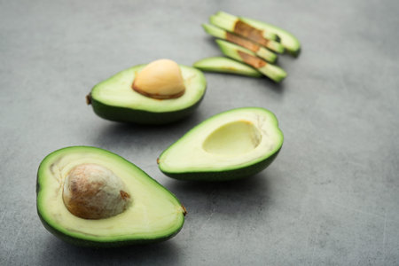 Raw green avocado on a stone table. Diet meal