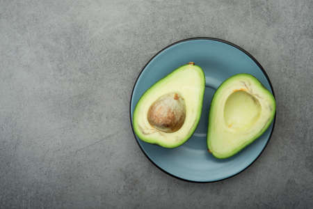 Raw green avocado on a stone table. Diet meal. Top viewの写真素材