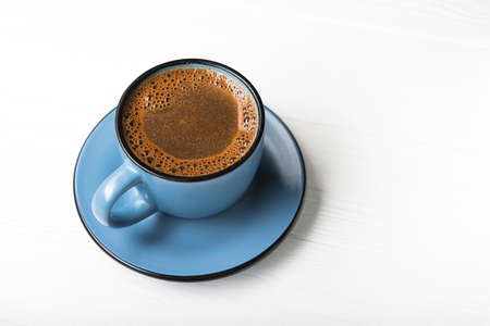 Blue coffee cup on a white wood tableの写真素材