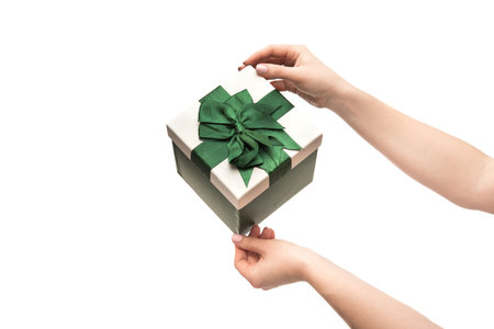 Woman hands holds present gift box with ribbon isolated on a white background