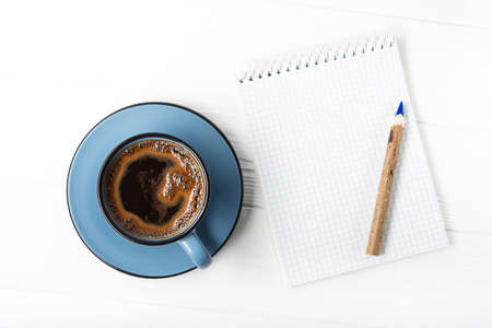 Coffee cup with notebook and pencil. Start of the day, schedule of cases. Top viewの写真素材