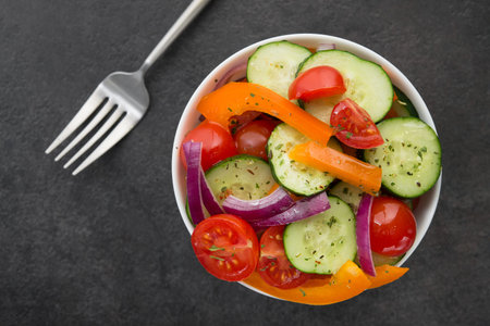 Fresh vegetables salad, tomato, pepper, cucumber in bowl on stone table. Healthy food diet. Top viewの写真素材