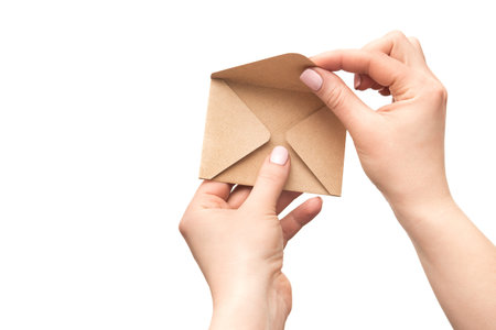 Female hand holds an vintage old envelope isolated on a white background