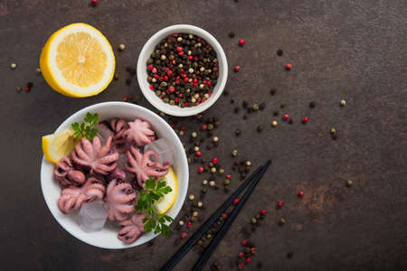 Pickled octopus with lemon and parsley on a plate. Tasty exotic food. Top viewの写真素材