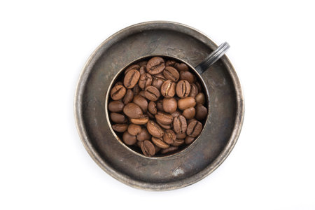 Old vintage coffee cup filled with roasted beans isolated on a white background. top viewの写真素材