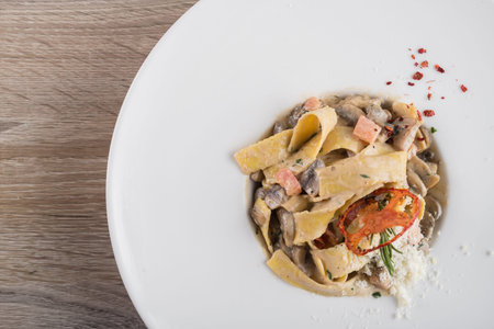 delicious pasta with vegetables and parmesan cheese on a white plate. top view