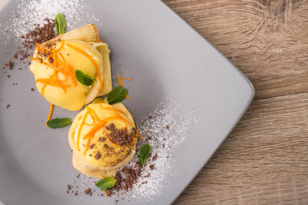 Sweet pancake with peach and chocolate, green mint on a plateの写真素材