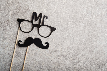 funny faces formed from black photo boots, mustache and glasses on a stone background. concept of holiday father day.の写真素材