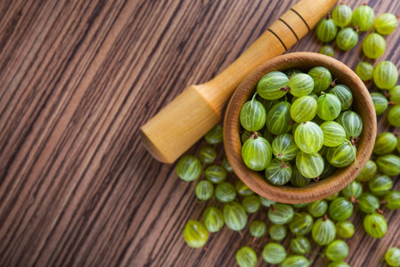 green fresh gooseberry in a bowl on wooden table. cooking jam  ingredient