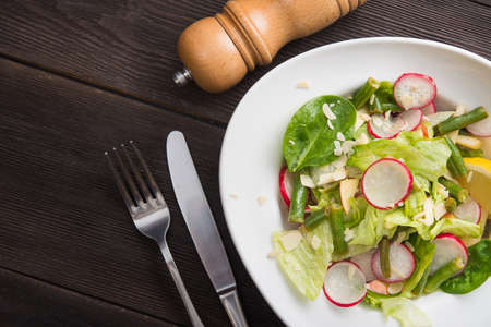 Fresh salad with radish and asparagus on a wooden table. diet and vegan food. top viewの写真素材