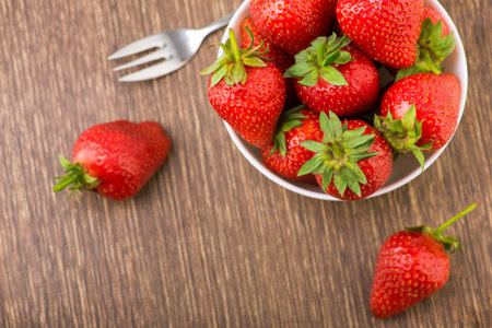 Fresh red strawberry in a bowl on table. Sweet summer dessert backgroundの写真素材