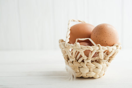 raw eggs in the basket on a wooden backgroundの写真素材