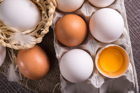 raw egg in a tray on a wooden table. rustic dairy background. top view