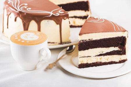 delicious piece cake with coffee cup on a white plate. sweet dinner background