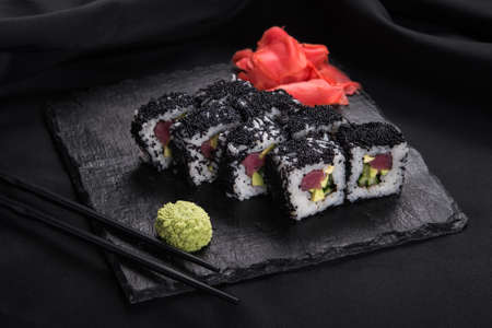 Black sushi roll with wasabi and ginger on a slate on backgroundの写真素材
