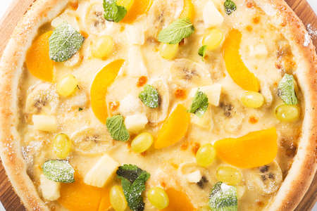 Close up of fruit sweet pizza with banana, grapes and mint. top viewの写真素材