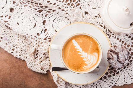Tasty hot cappuccino with a pattern on the foam. old rural style drink background. top viewの写真素材