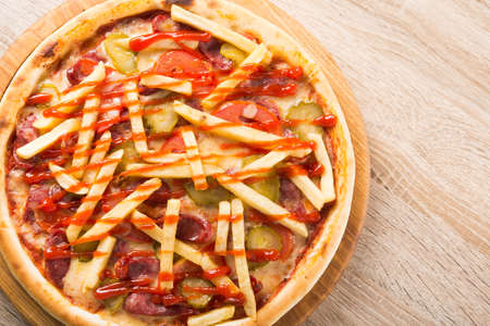American fast food pizza with potatoes and ketchup on wooden table. top viewの写真素材