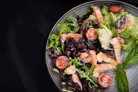 shrimp salad with vegetables on a black backgroundの写真素材