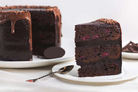 a piece of sweet chocolate cake on a white tablecloth. delicious calorie food.