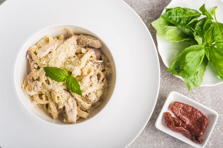 tasty italian pasta with basil and cheese on a stone table. top view
