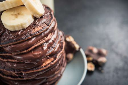 Sweet chocolate pancake with banana on a stone background. high-calorie breakfast. junk foodの写真素材