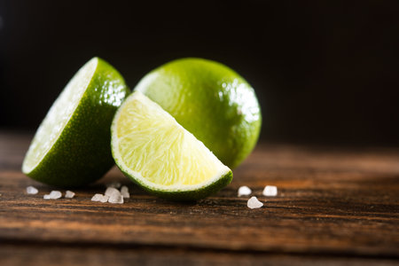 Fresh green lime on a wooden table with saltの写真素材
