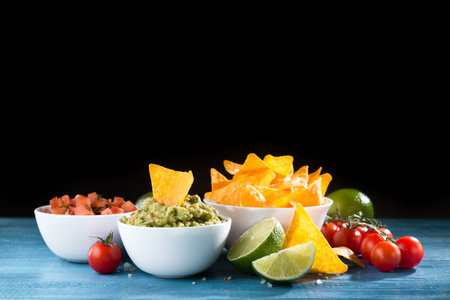Spicy golden crispy chips with salsa and guacamole sauce on a wooden table. mexican foodの写真素材