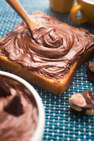 Sweet breakfast of bread with chocolate spread and a cup of coffee on the morning tableの写真素材