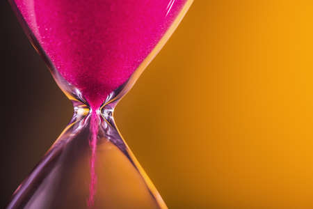 Bright colored time with hourglass on a yellowの写真素材