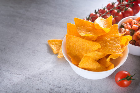 Tomato salsa with golden tortilla chips on a stone table. mexican foodの写真素材