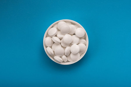 Medical white pills on a blue background. top view