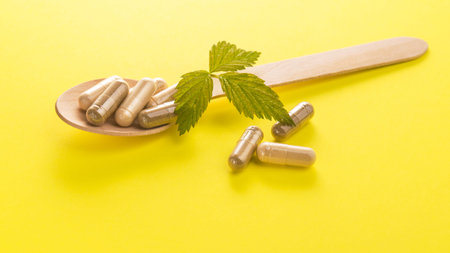 Herbal medical capsule on a yellow background. natural vitamin supplements in food