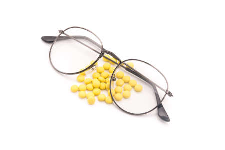 Vision glasses and pills vitamins for improving the eyes. Isolated on a white background.の写真素材