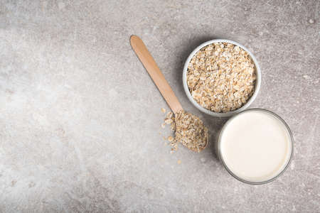 A glass of lean oatmeal milk on a stone background. vegetarian and organic drink food. top view.の写真素材