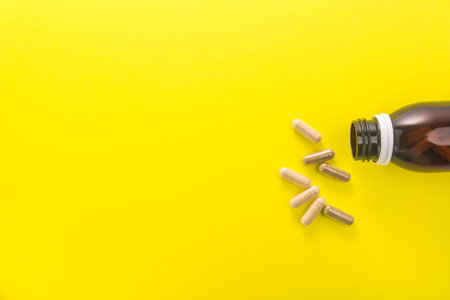 Herbal medical capsule on a yellow background. natural vitamin supplements in food. top view