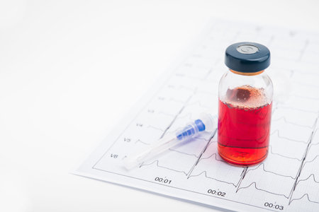 ECG results on paper and red injections to restore heart pulse. Heart attack or hypertension