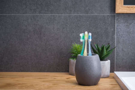 Toothbrushs in bathroom of scandinavian style, wood and stone material. place for text