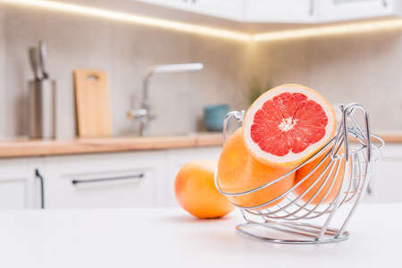 Close up of fresh red grapefruits on a wooden white table on a kitchen.の写真素材