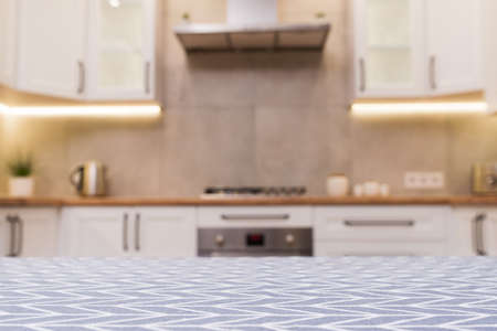 Focus on a vintage tablecloth table and scandinavian kitchen defocused on background.の写真素材