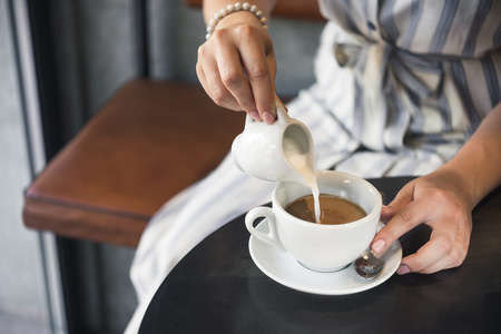 Young girl in a cafe with a cup of americano coffee.の写真素材