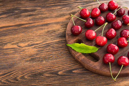 Fresh red cherries on a wooden table. Rustic harvest concept. Bio and eco berries.