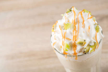 Sweet milk shake cocktail with kiwi and caramel topping. Summer dairy beverage.の写真素材