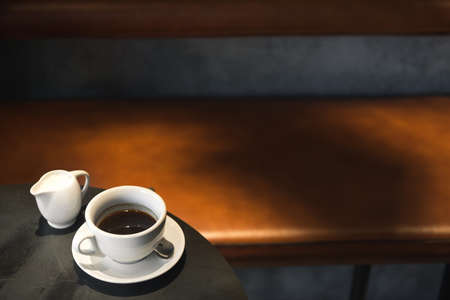 White espresso coffee cup on a black metal cafe table. space for text.の写真素材