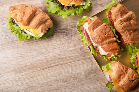 Set of fresh homemade croissants with cheese and bacon on a wooden table. Fast food snack. Top viewの写真素材