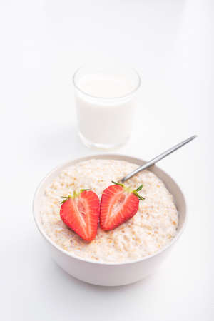 Sweet porridge with red strawberry and glass of milk. healthy morning breakfast.の写真素材