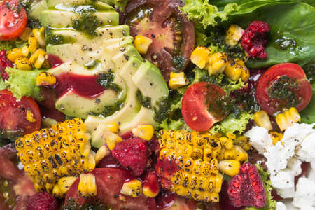 Beautiful display dishes of salad with avocado, corn, tomato and spinach leaves on a table in cafe. top view.の写真素材