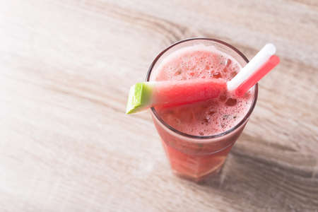 Glass of cold summer watermelon smoothie drink on a cafe table.の写真素材