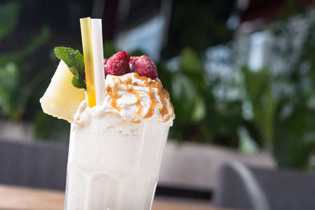 Closeup of tasty summer milk shakes with melon slice and caramel topping on a cafe table.の写真素材