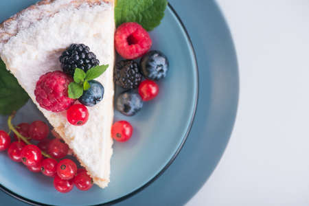Sweet dessert cake with fresh blackberry, raspberry, currants and blueberry and green mint.の写真素材